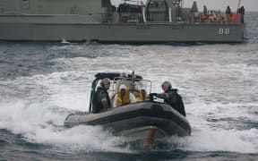 Australian navy personnel transfer Afghanistan asylum-seekers to a Indonesian rescue boat near Panaitan island, West Java on August 31, 2012 after the refugee's boat sunk.