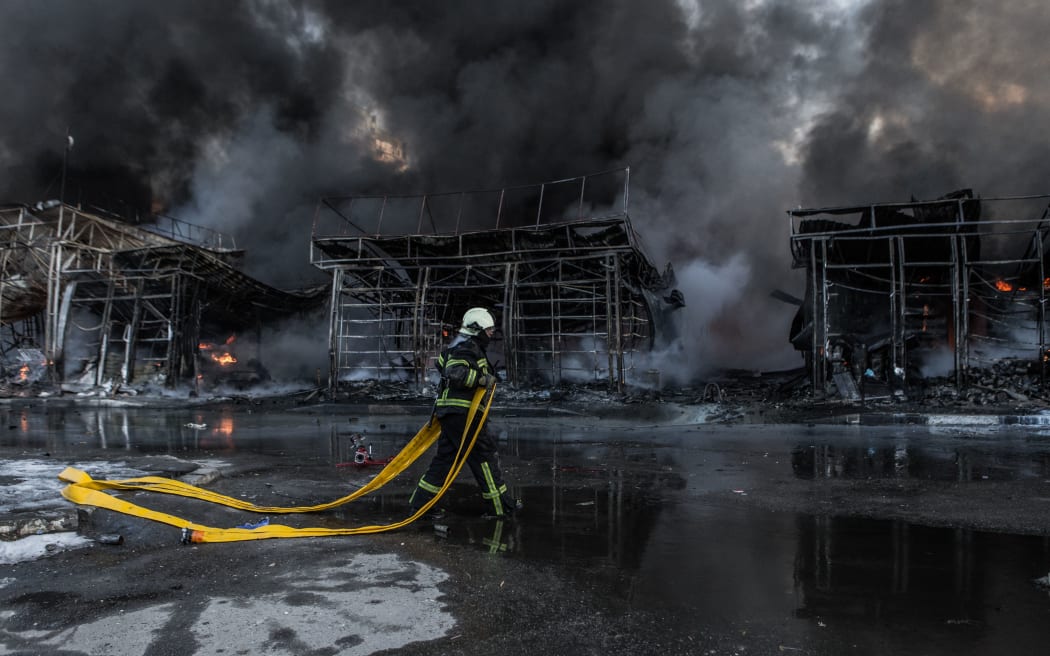 KHARKIV, UCRANIA - 16 DE MARZO: Los bomberos intentan extinguir un incendio en el mercado de la construcción de Saltivka, alcanzado por 6 rondas de artillería pesada rusa en Kharkiv, Ucrania, el 16 de marzo de 2022.