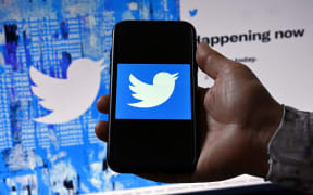 (FILES) In this file photo illustration taken on April 26, 2022, a phone screen displays the Twitter logo on a Twitter page background, in Washington, DC. - Twitter misled users and federal regulators about glaring weaknesses in its ability to protect personal data, the platform's former security chief claimed in whistleblower testimony likely to impact the company's bitter legal battle over Elon Musk's takeover bid. In a complaint filed with the US Securities and Exchange Commission and published in part August 23, 2022, by The Washington Post and CNN, Peiter Zatko also accused Twitter of significantly underestimating the number of automated bots on the platform -- a key element in Musk's argument for withdrawing his $44 billion buyout deal. (Photo by Olivier DOULIERY / AFP)
