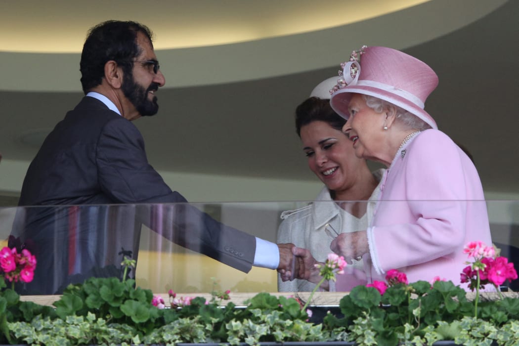 Queen Elizabeth II greets Emir of Dubai Sheikh Mohammed bin Rashid al-Maktoum and Jordan's Princess Haya bint al-Hussein (centre) at the Royal Ascot horse racing meet on June 15, 2016.