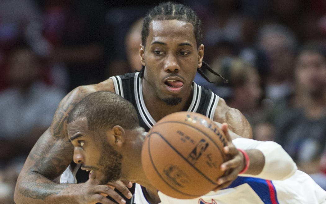 Clippers' Chris Paul drives the lane against Spurs' Kawhi Leonard