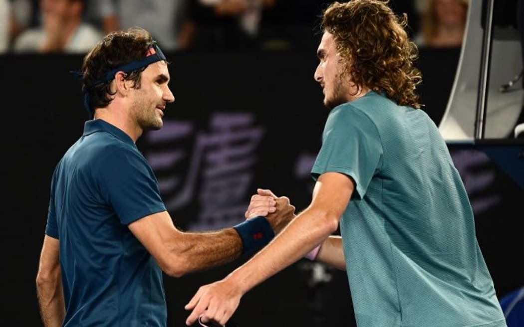 Switzerland's Roger Federer (L) shakes hands with Greece's Stefanos Tsitsipas after defeat in their men's singles match on day seven of the Australian Open tennis tournament in Melbourne on January 20, 2019.