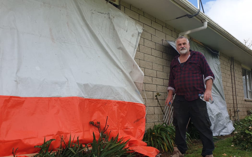 John Bamford outside his New Plymouth home that was damaged by the storm, which also injured his wife.