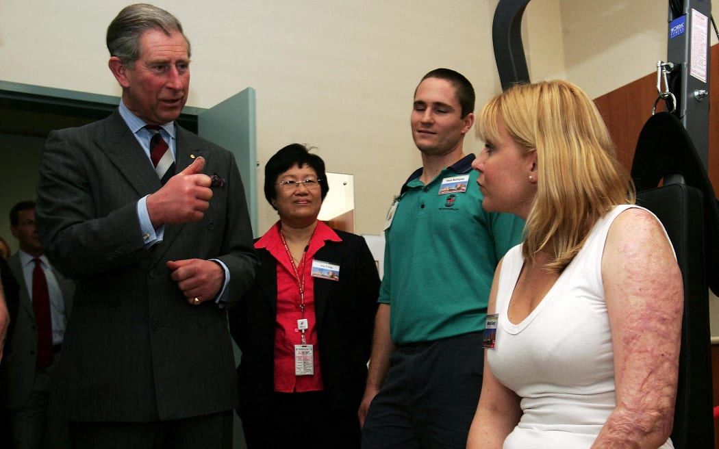 El rey Carlos III (izquierda), entonces príncipe, se encuentra con la víctima del bombardeo de Bali, Melinda Kemp, mientras visita una sala de rehabilitación en el Royal Perth Hospital, Perth, el 1 de marzo de 2005.