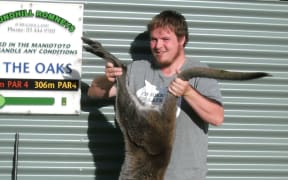 Maniototo Pest Management assistant manager Adam Mulholland with a wallaby he shot on Ranfurly Golf Course.