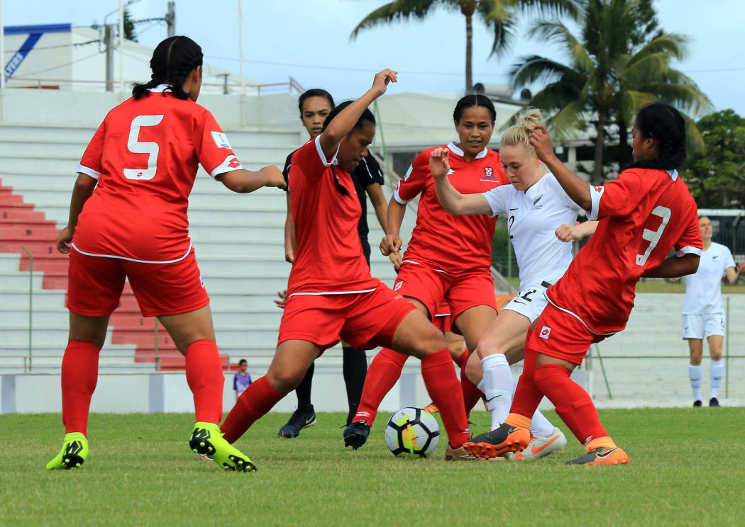 The Tongan defence swarms New Zealand's Betsy Hassett.
