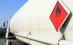 A fuel and flammable liquid tanker truck with a fire hazard warning sticker.