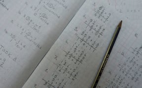 Open maths book with workings