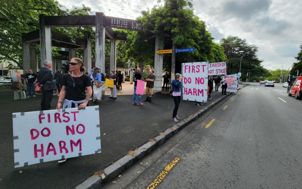 Supporters outside the High Court in Auckland where Te Whatu Ora is taking a case against parents who are refusing to allow blood from vaccinated people to be used during their baby's life-saving heart operation.