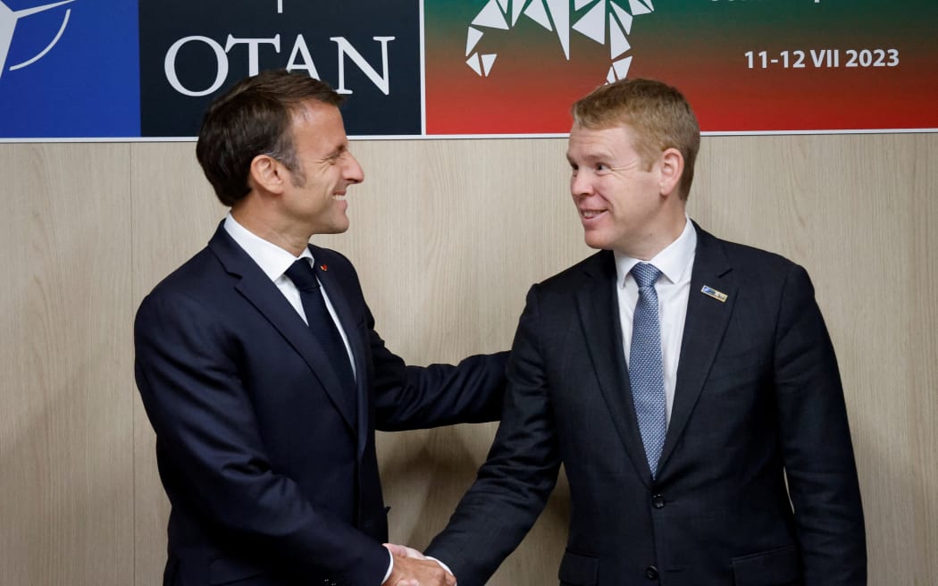 French President Emmanuel Macron, left, shakes hands with New Zealand Prime Minister Chris Hipkins on the sidelines of the NATO summit, in Vilnius on July 11, 2023.