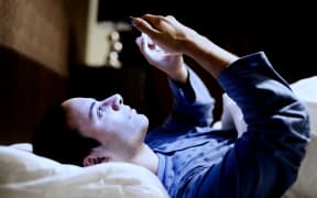 Man in bed with smartphone - blue light