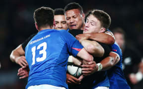 Beauden Barrett is wrapped up by Alapati Leiua and Kieron Fonotia during the Pasifika Challenge test between the All Blacks and Manu Samoa.