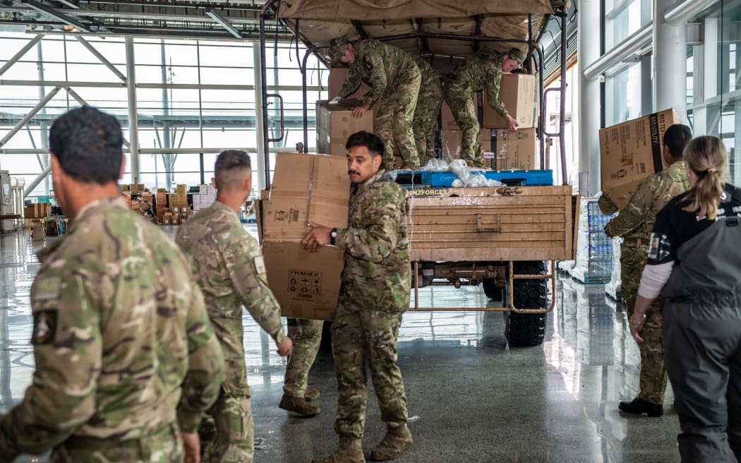 Army personnel from 16 Field Regiment unload supplies at the Central Distribution Centre in Auckland alongside volunteers from the Auckland City Council. Essential supplies such as blankets, torches and pillows will be distributed throughout Auckland as part of Op Awhina.