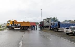 Trucks block the entrance of a Noumea blockade as part of a protest that has ground the city to a standstill