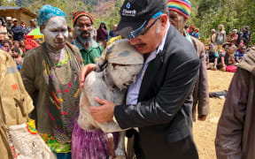 Peter O’Neill comforts a woman in an area affected by the 7.5 quake.