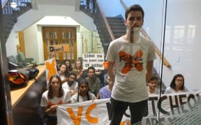 Alex Johnston, from Fossil Free University of Auckland, with other protestors locked in the Vice-Chancellor's reception area by campus security, after occupying a wing of the administration block.