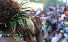 A Solomon Islands' cultural performer blows a conch shell to announce the arrival of Pacific leaders for the RAMSI farewell events. June 2017