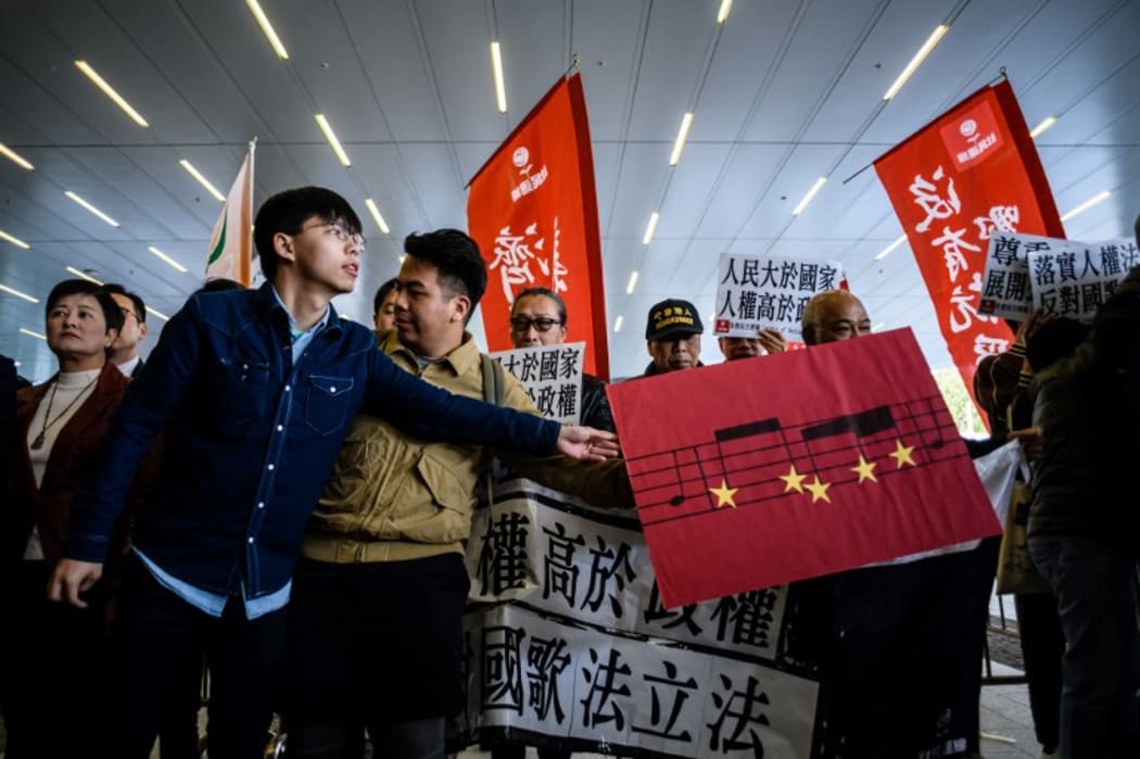 Hong Kong pro-democracy activist Joshua Wong (L)  during a protest outside the Legislative Council, against a proposed law to punish anyone who disrespects the Chinese anthem with up to three years in jail.