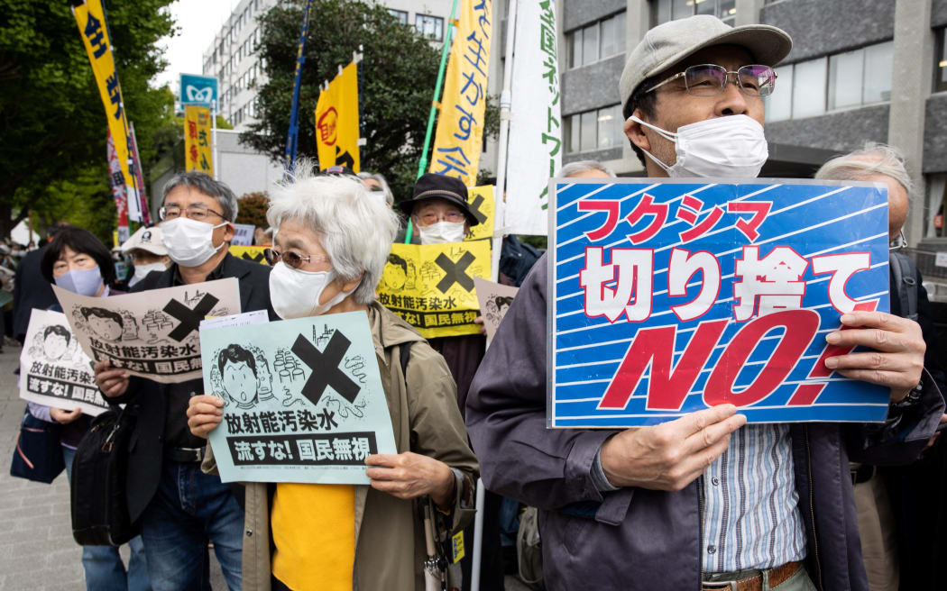 Göstericiler, 13 Nisan 2021'de hükümetin Fukushima nükleer santralinden arıtılmış suyu okyanusa salma planına karşı Japon başbakanlığının önünde düzenlenen protesto sırasında sloganlar atıyor.