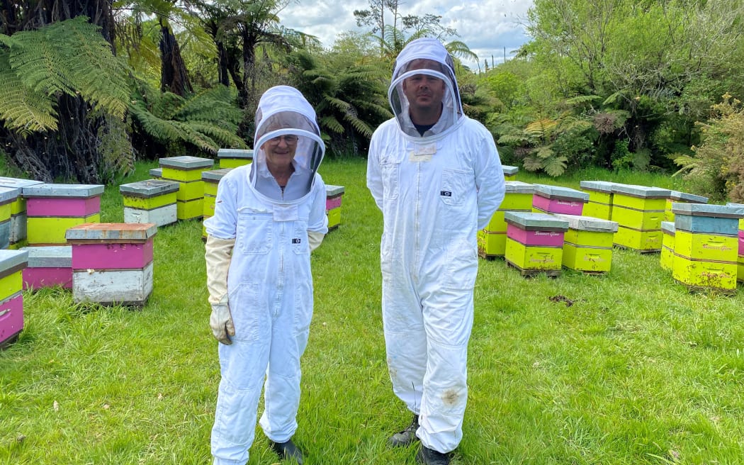 Margaret Bennett (left) and son-in-law and beekeeper James Jeffery (right) stand in their bee suits in the middle of the hives.