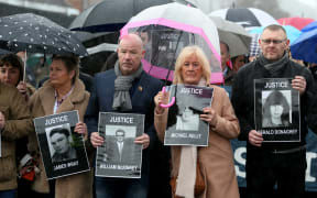 Relatives and supporters of the victims of the 1972 Bloody Sunday killings hold images of those who died.