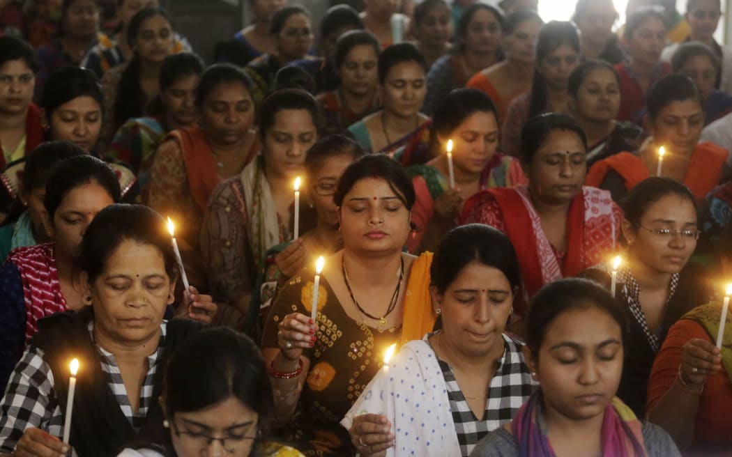 Indian staff at a school pray for the victims of Sunday's blasts in Sri Lanka, in Ahmadabad, India, Monday, April 22, 2019.