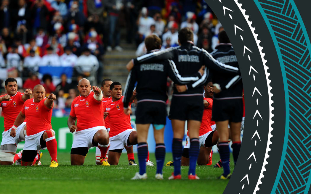 A photo of the Tonga team performing the Sipi Tau prior to kickoff during the Rugby World Cup Pool A match between France and Tonga at Wellington Regional Stadium on October 1, 2011 in Wellington, New Zealand.  The Tongan team is in the background facing the camera, while the French team is in the foreground, watching the performance with their backs to the camera.