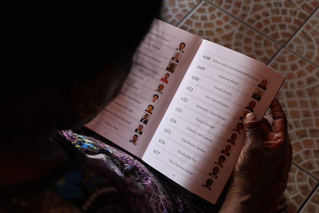 A prospective voter in Fiji studies her voter instruction booklet. November 2018