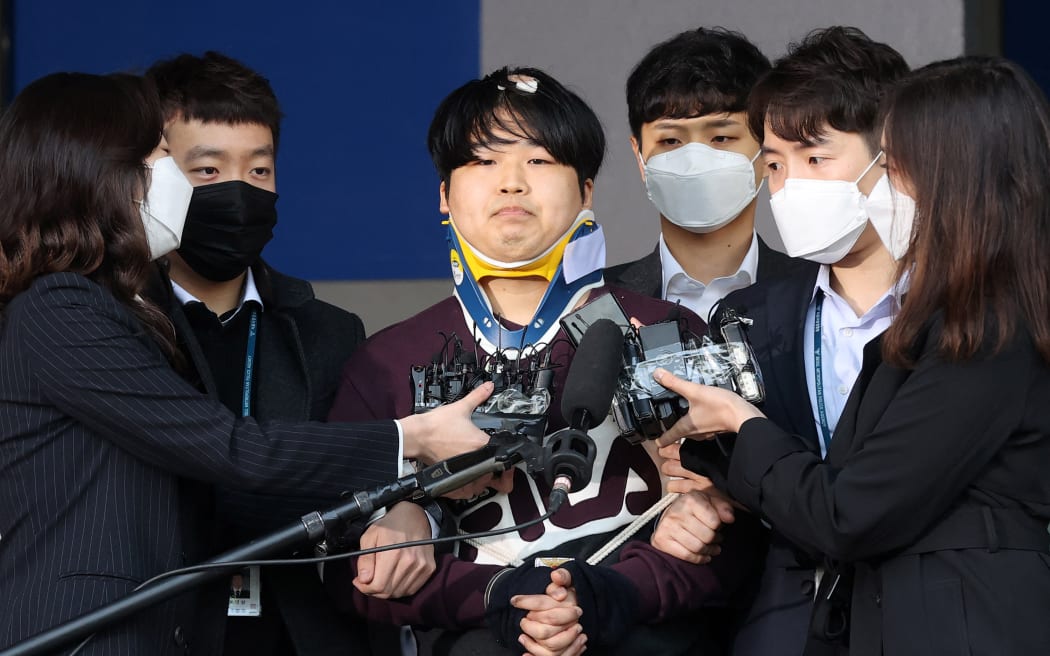 Cho Ju-bin (centre), who ran an online sex abuse ring, walking out of a police station on 25 March, 2020, as he is transferred to the prosecutors' office in Seoul.