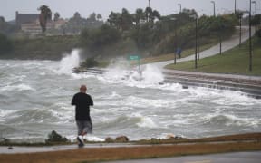 Sal Valerio walks near the bay waters as they churn from approaching Hurricane Harvey.