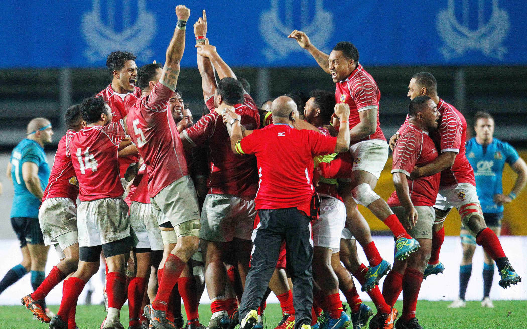 The Tonga rugby team celebrates their win over Italy