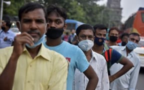 People stand on a line without maintaining social distancing amid coronavirus emergency in Kolkata, India,  on 8 October, 2020.