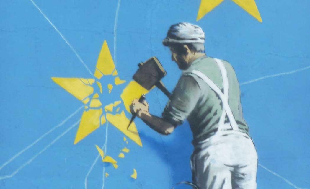 Banksy Brexit mural of man chipping away at EU flag
