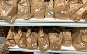 brown paper bags with numbers labels sit on a shelf