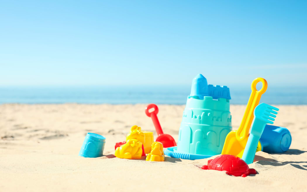 Different child plastic toys on sandy beach