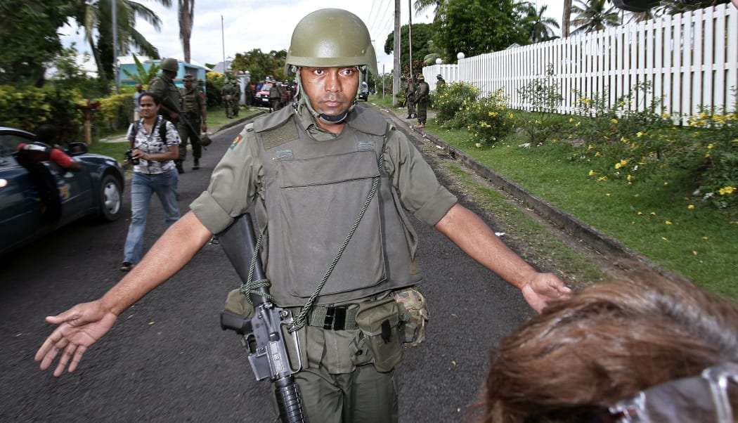 A soldier orders media to back off as the army moves on the residence of Laisenia Qarase, blocking the view of the house where the premier was meeting with key ministers, 5 December 2006.