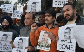 Indian people hold placards and photographs of Indian Air Force pilot Abhinandan Varthaman, as they celebrate the announcement of his soon release, in Amritsar.