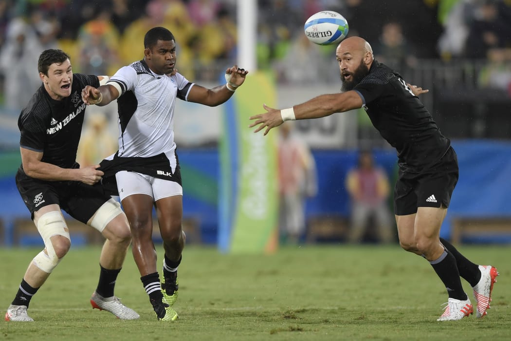 New Zealand's Sam Dickson (L) tackles Fiji's Vatemo Ravouvou (2nd L) as New Zealand's D J Forbes reaches for the ball in the men’s rugby sevens quarter-final match between Fiji and New Zealand during the Rio 2016 Olympic Games in Rio de Janeiro on August 10, 2016.