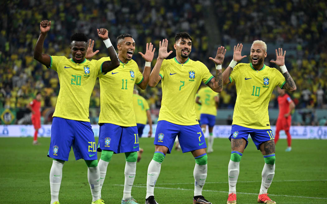 Brazil forward Neymar celebrates with Vinicius Junior, Raphinha and Lucas Paqueta after scoring his team's second goal from the penalty spot during the Qatar 2022 World Cup round of 16 football match between Brazil and South Korea at Stadium 974 in Doha on December 5, 2022.