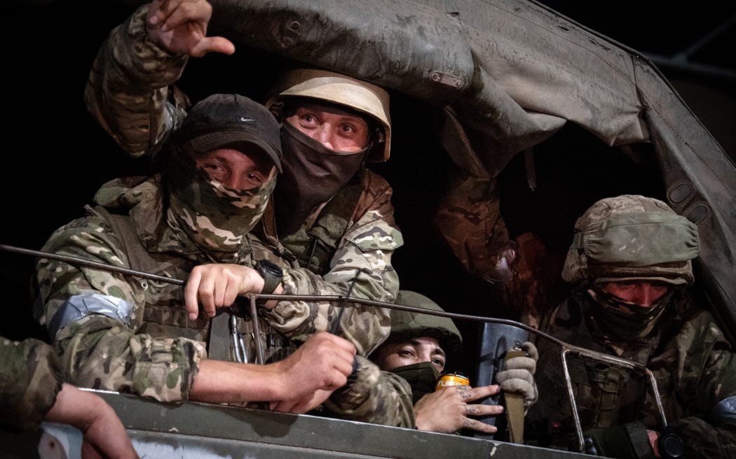 Members of Wagner group looks from a military vehicle in Rostov-on-Don late on June 24, 2023. Rebel mercenary leader Yevgeny Prigozhin who sent his fighters to topple the military leaders in Moscow will leave for Belarus and a criminal case against him will be dropped as part of a deal to avoid 