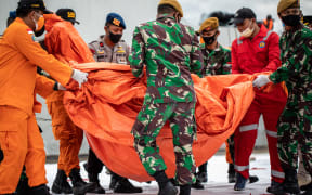 Rescue personnel moving bodies and debris recovered from the crash site of Sriwijaya Air flight SJ182 at the port in Jakarta on January 10, 2021.