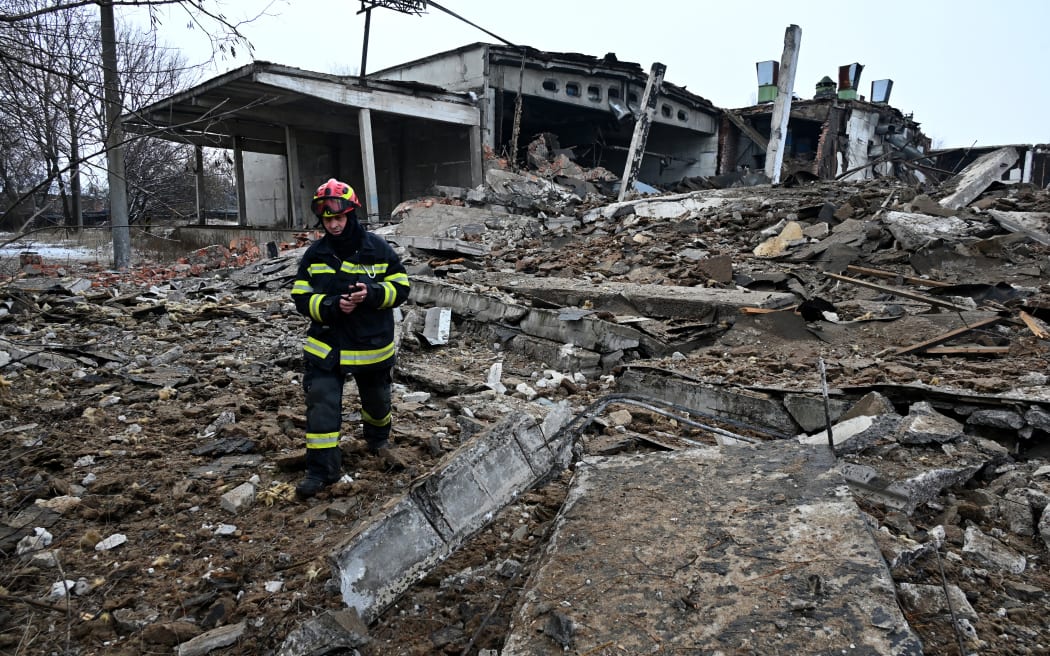 A rescuer walks amid rubbles of a destroyed building following Russian strikes in Kharkiv, eastern Ukraine on 16 December, 2022.