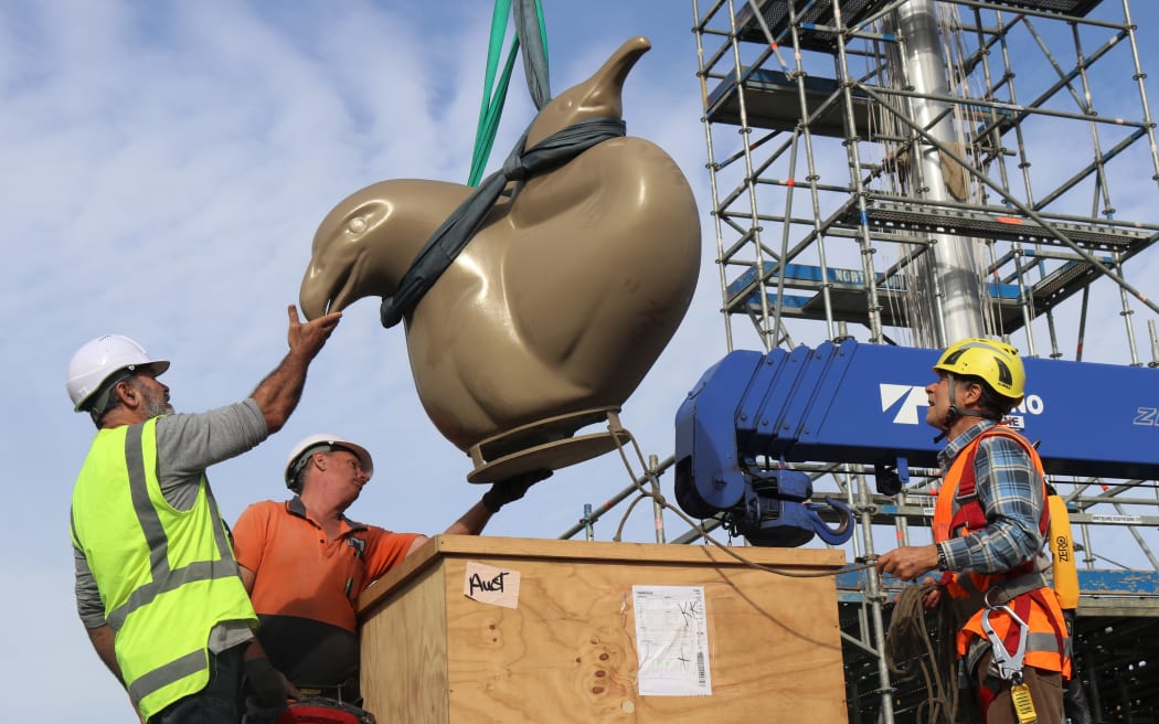 The repaired manu (bird) sculpture is returned to its roost at the top of Te Haa o Te Ao by, from left, Ngāti Rēhia leader Kipa Munro, hiab operator Brandon Peace and artist Chris Booth.