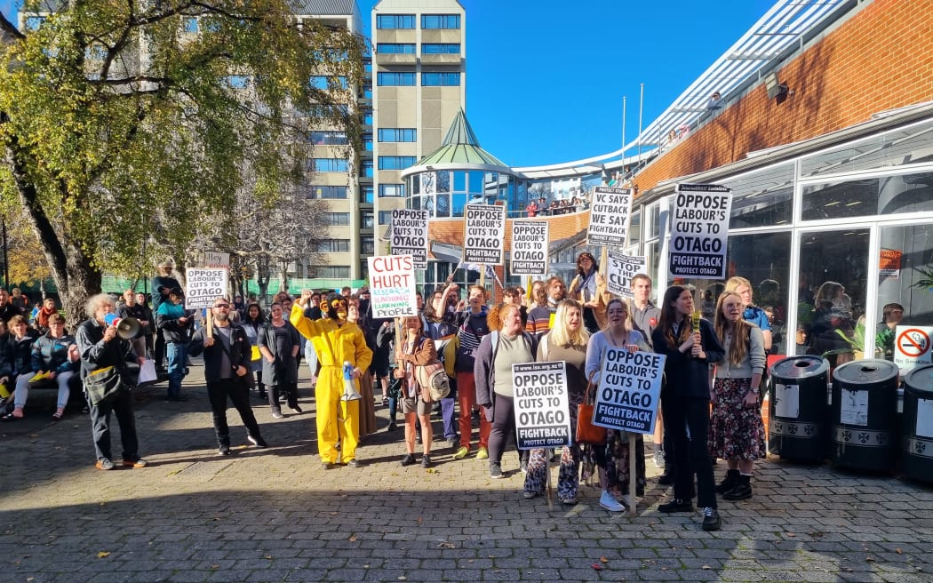 Protesters at the University of Otago during Prime Minister Chris Hipkins' visit to the campus, including the yellow-suited monkey who has become a feature of recent university protests.
