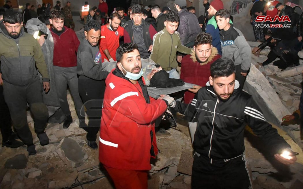 Rescuers evacuate a victim from an eight-storey building that collapsed after an 7.8-magnitude earthquake in southern Turkey.
