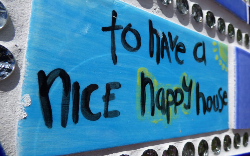 Tile on wall of hope with the words - to have a nice happy house
