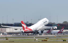 A Qantas Airways plane takes off at Sydney Airport in Sydney on March 19, 2020.