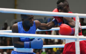 Pacific Games boxing round of 16:  Solomon Islands boxer Maximillian Makana’s (blue) left hook featured prominently in his 4-1 split decision win over Floyd Kunnopi from Papua New Guinea. Friendship Hall Honiara 27 November 2023 credit RNZ Pacific/Koroi Hawkins