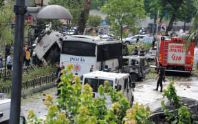Police officers and rescuers inspect the site of a bomb attack that targeted a police bus in the Vezneciler district of Istanbul on 7 June 2016.