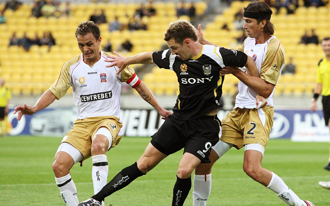 Jade North (left) and Adam Griffiths try to dispossess Shane Smeltz.
A-League soccer. Wellington Phoenix v Newcastle Jets at Westpac Stadium, Wellington. Sunday, 23 November 2008.